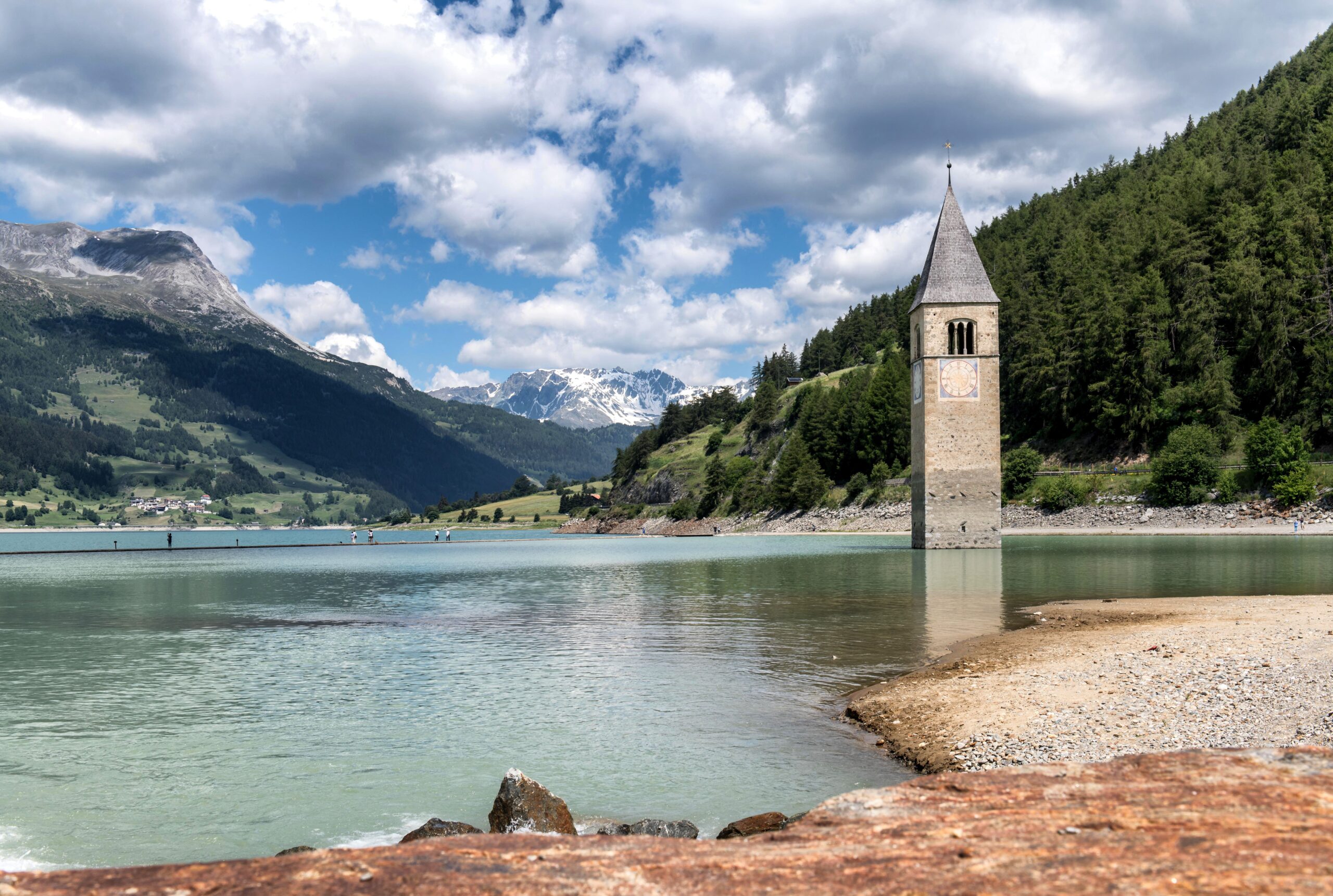 Der versunkene Kirchturm im Reschensee, umgeben von den Alpen